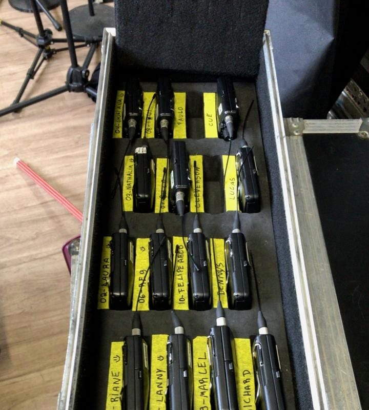 In-ear monitor drawer — molded earpieces in labeled cubbies marked BRIANE, LANNY, MARCEL, cables coiled beside each.