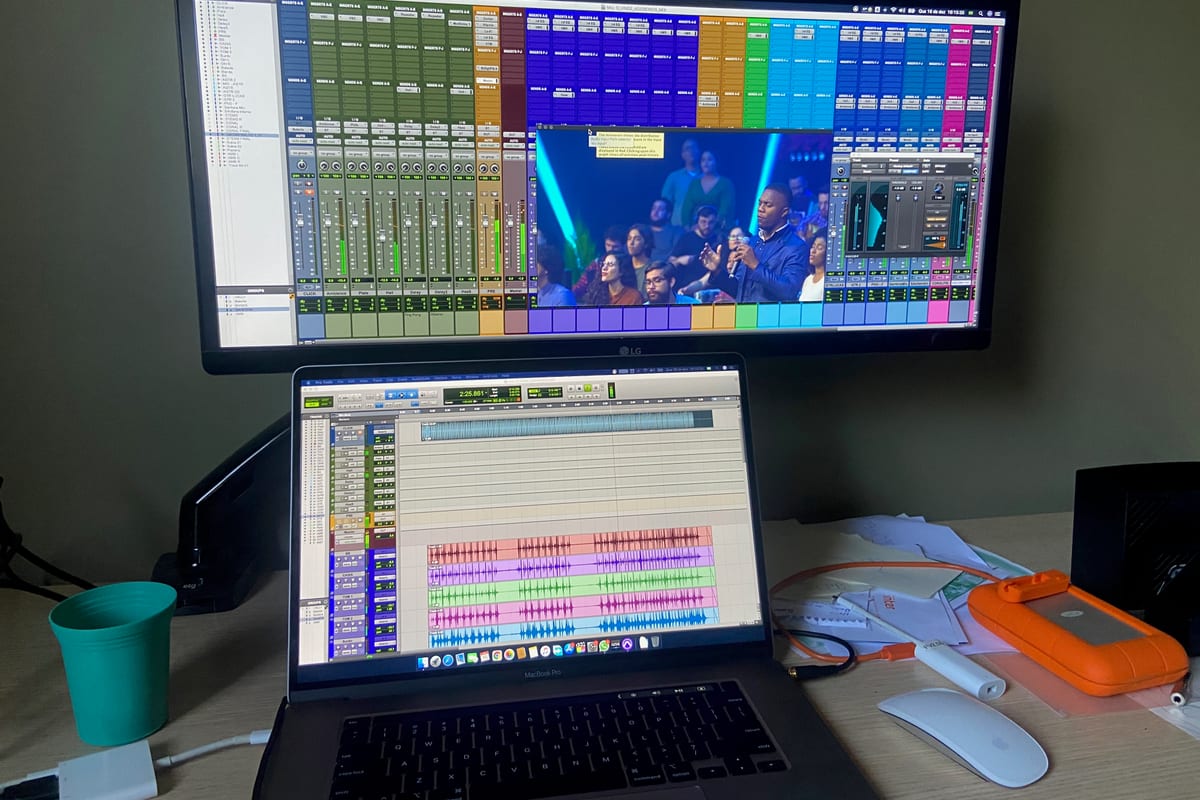 Pro Tools session on screen, broadcast feed picture-in-picture in the corner — multitrack arrange window mid-edit, transport stopped on a downbeat.