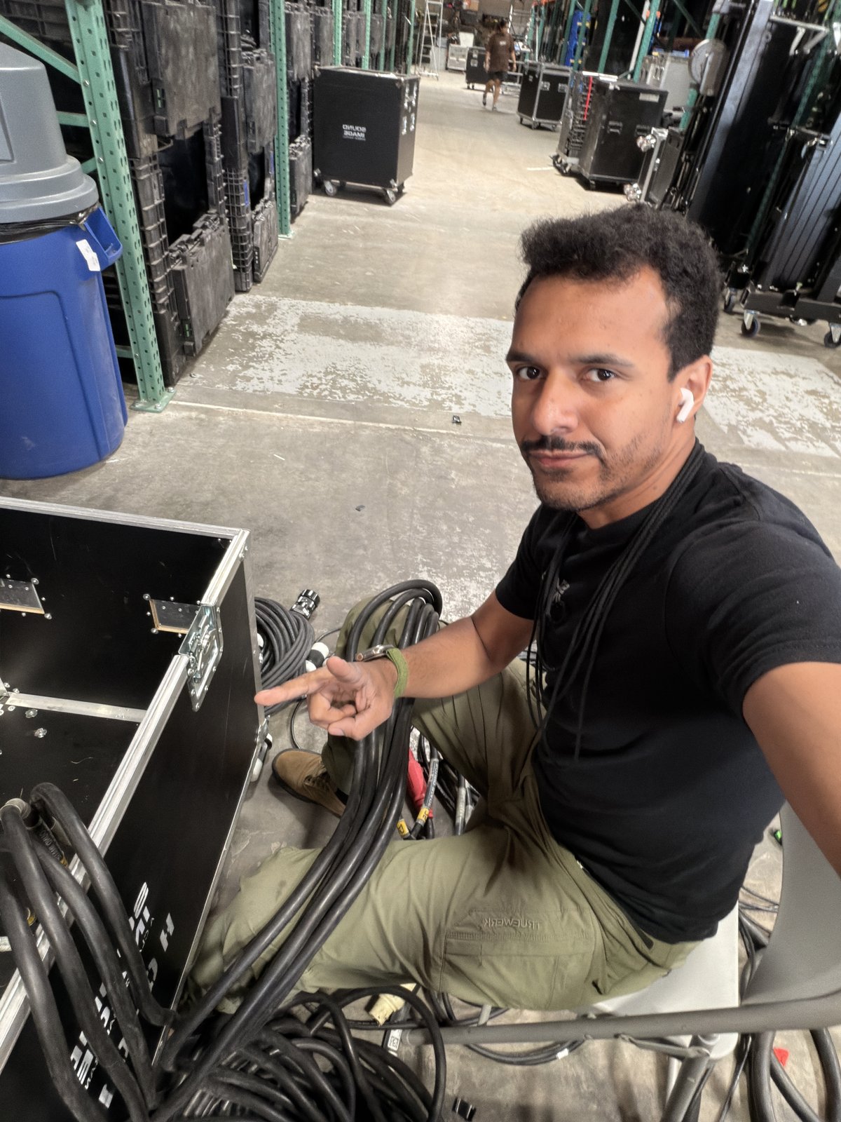 Victor prepping cable at the Sound Image warehouse — coiling power and signal runs at a road case before a show.