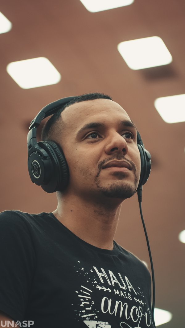 Portrait of Joao V. Rocha in headphones at the monitor position, UNASP.